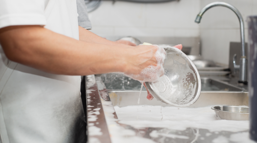 Mitarbeiter *in Spülküche • Person wäscht eine Schale in einer Restaurant Küche • Offene Stellen Gastronomie • Karriere bei Meyerhoff