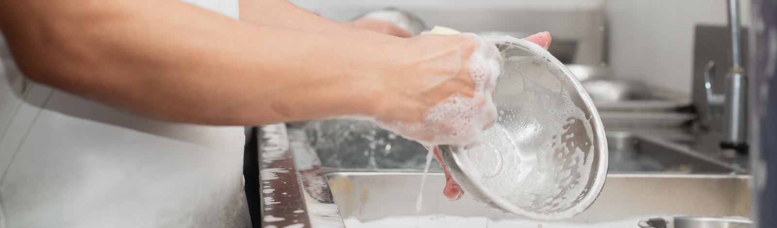 Mitarbeiter *in Spülküche • Person wäscht eine Schale in einer Restaurant Küche • Offene Stellen Gastronomie • Karriere bei Meyerhoff